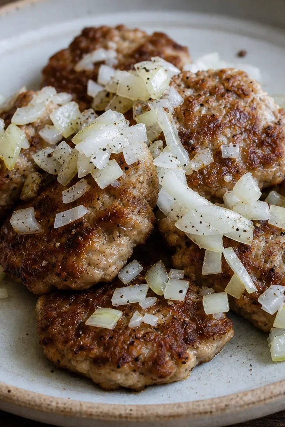 Golden-brown Danish frikadeller served with potatoes and pickled vegetables, showcasing their juicy texture.