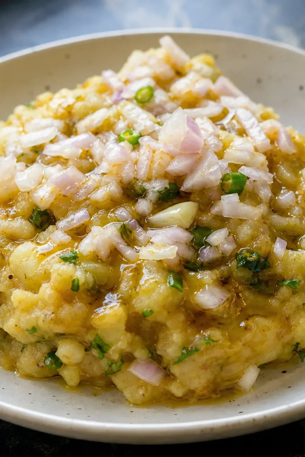Smooth mashed potatoes mixed with mustard oil and green chilies, garnished with fresh coriander.
