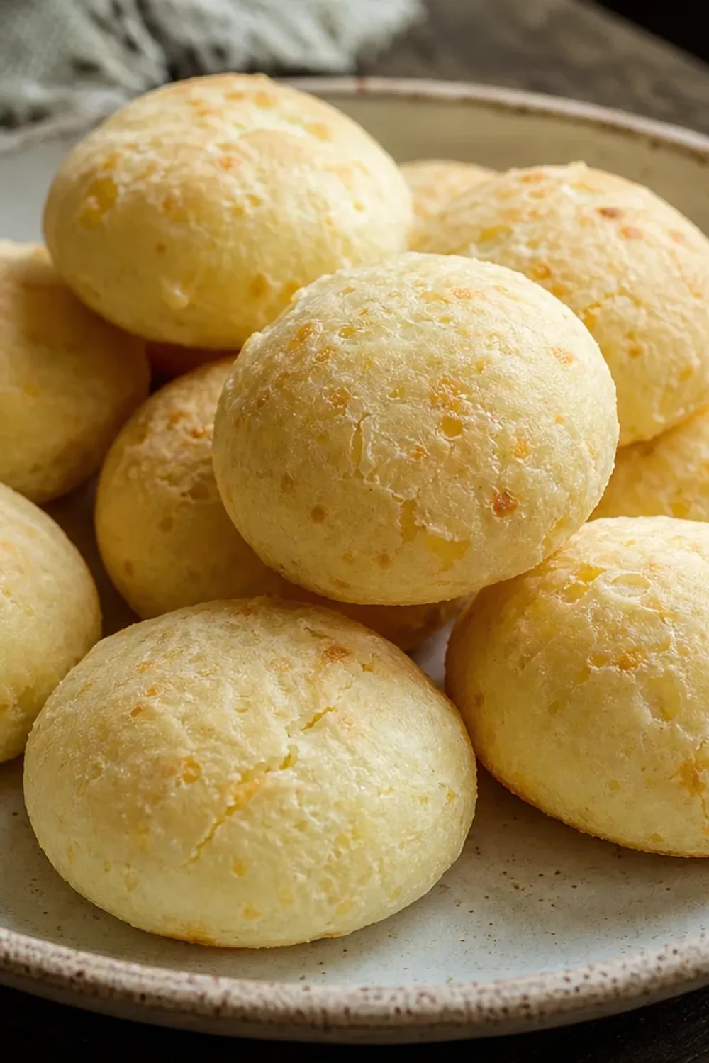 Golden brown cheese bread with a crispy exterior and soft, chewy interior, garnished with fresh herbs.