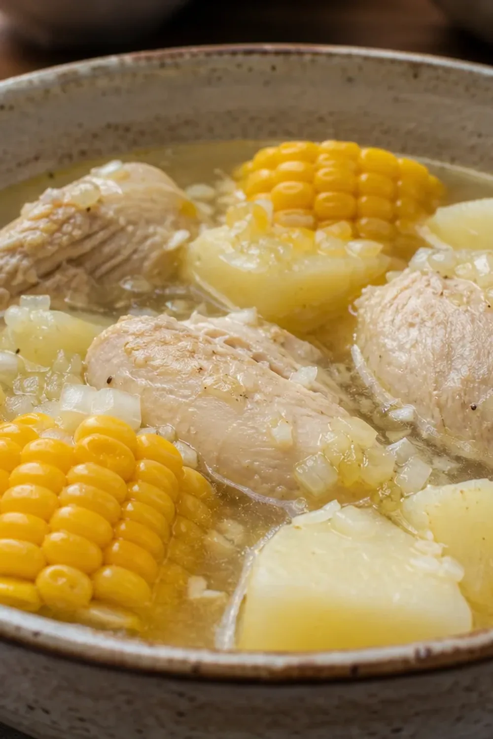 Hearty Colombian Ajiaco soup garnished with avocado, chicken, and corn.