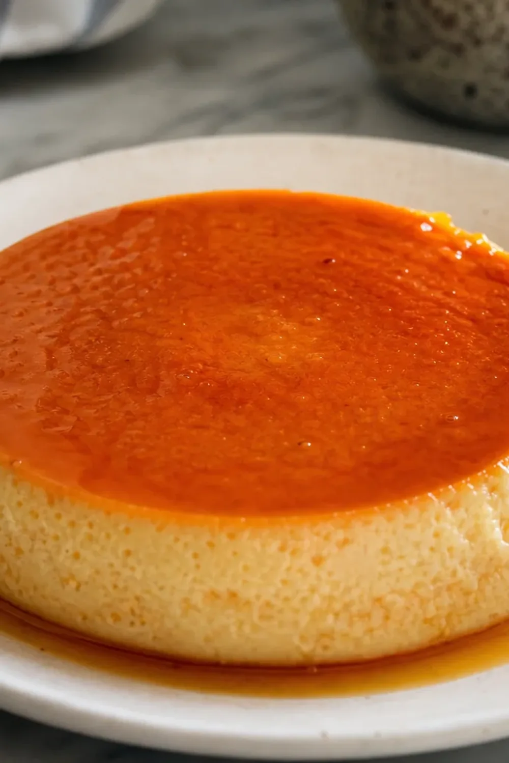 Smooth caramel custard flan topped with a glossy caramel layer, garnished elegantly.
