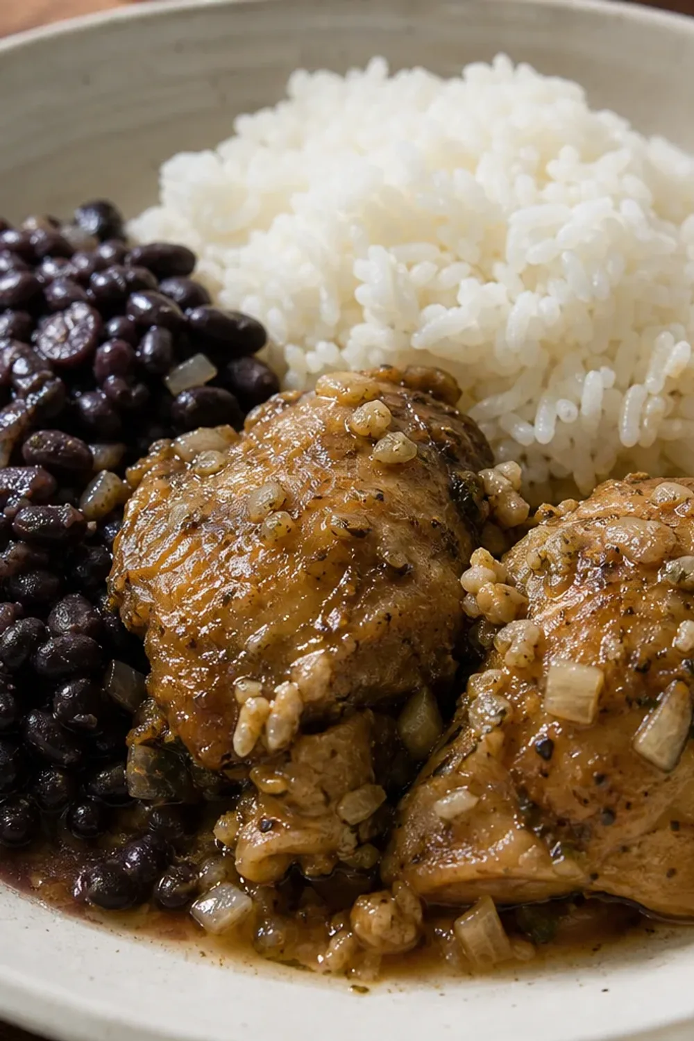 Colorful plated La Bandera with tender chicken, white rice, and black beans garnished with fresh herbs.