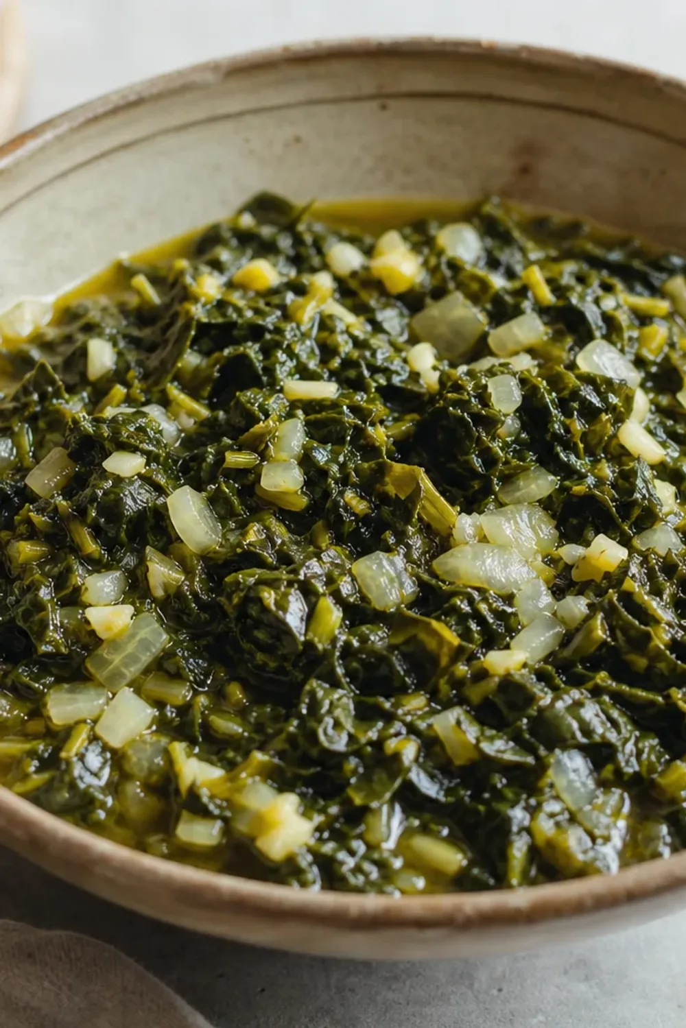 Plated Ethiopian Gomen with vibrant collard greens, garlic, and spices, garnished and served warmly.
