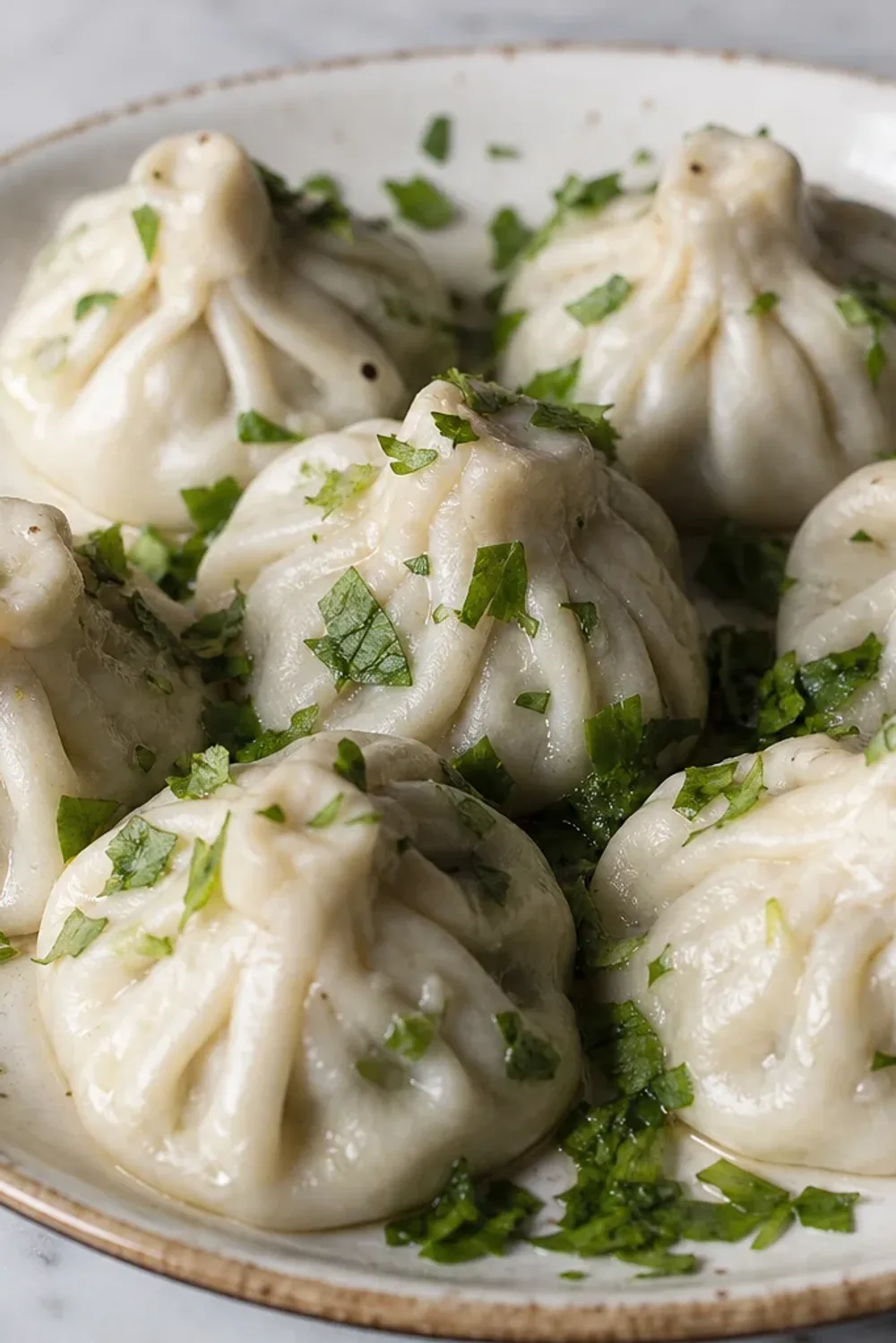 Plated khinkali dumplings showcasing juicy beef filling and fresh herbs, garnished with parsley.
