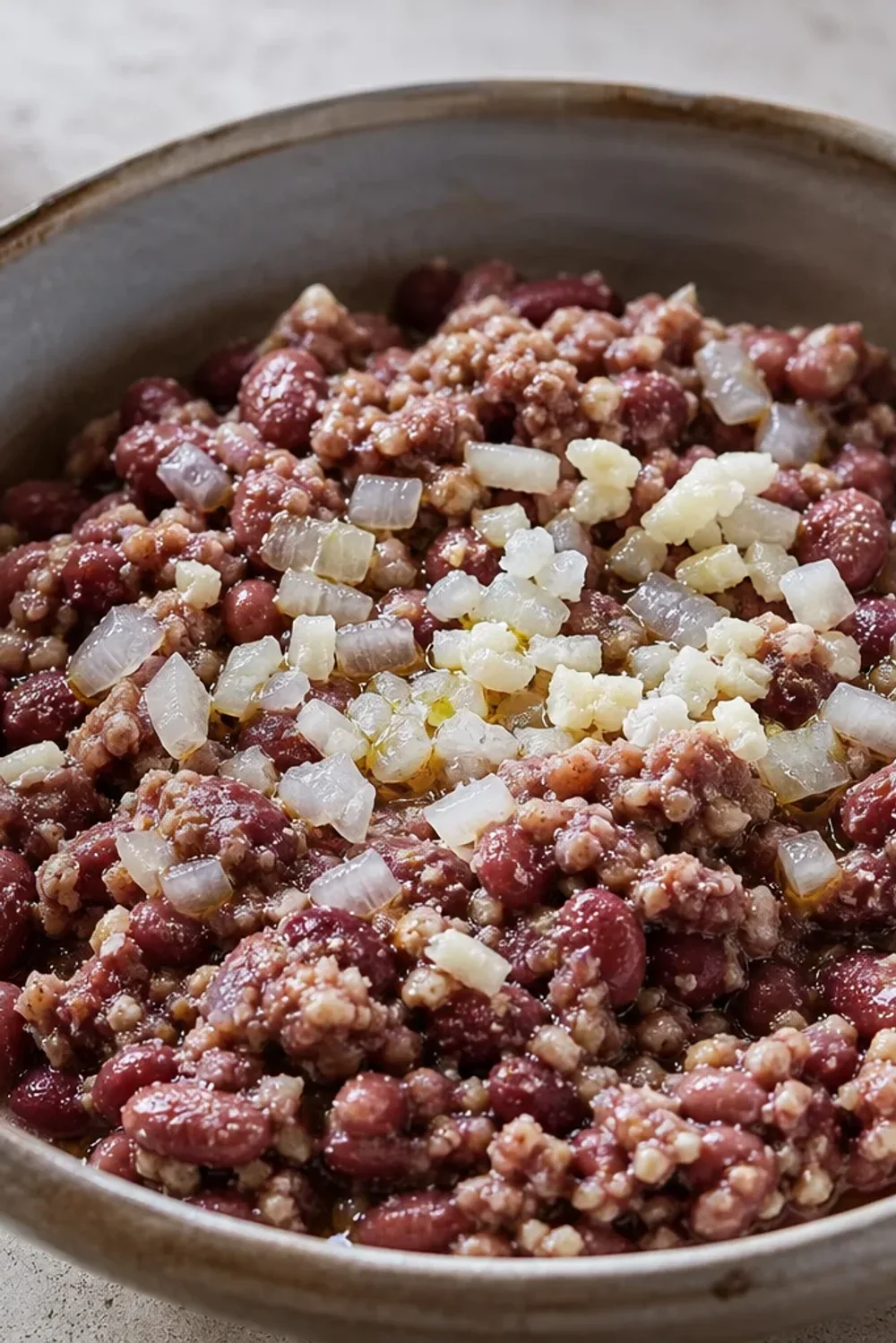 A hearty bowl of Georgian Lobio with red beans, chopped walnuts, and vibrant fresh herbs garnished beautifully.