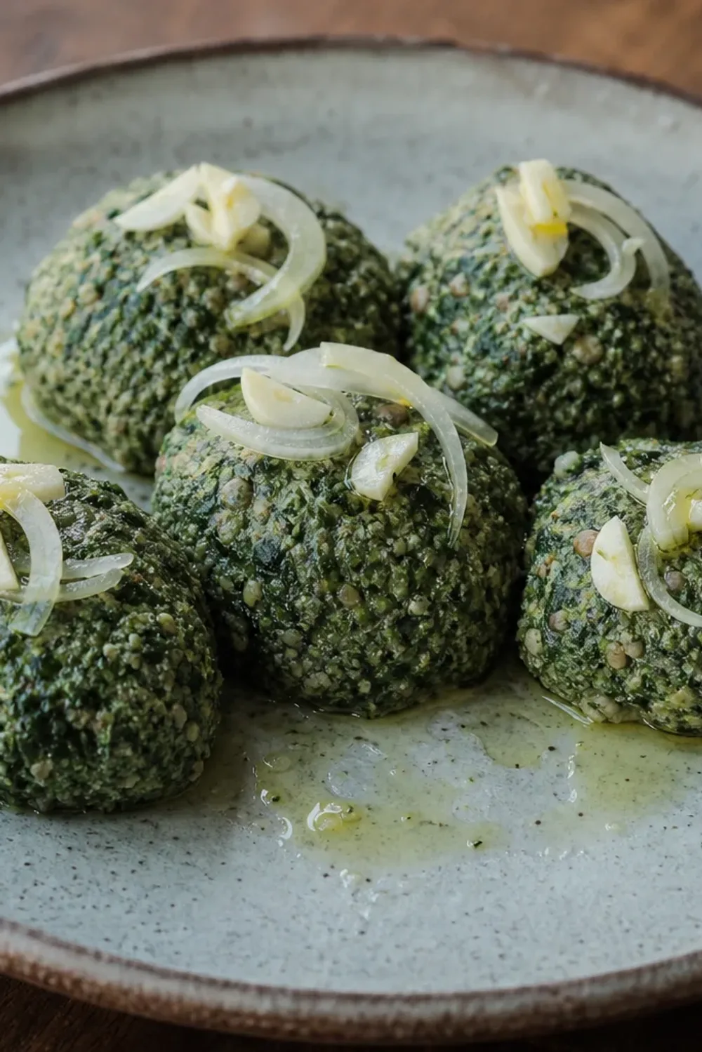 A vibrant dish of Georgian pkhali showcasing a green spinach and walnut mixture garnished with herbs and served in a bowl.