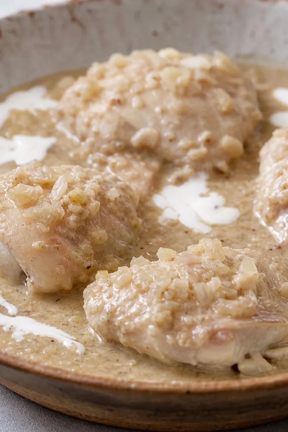 Tender chicken pieces coated in a creamy walnut sauce, garnished with herbs on a white plate.