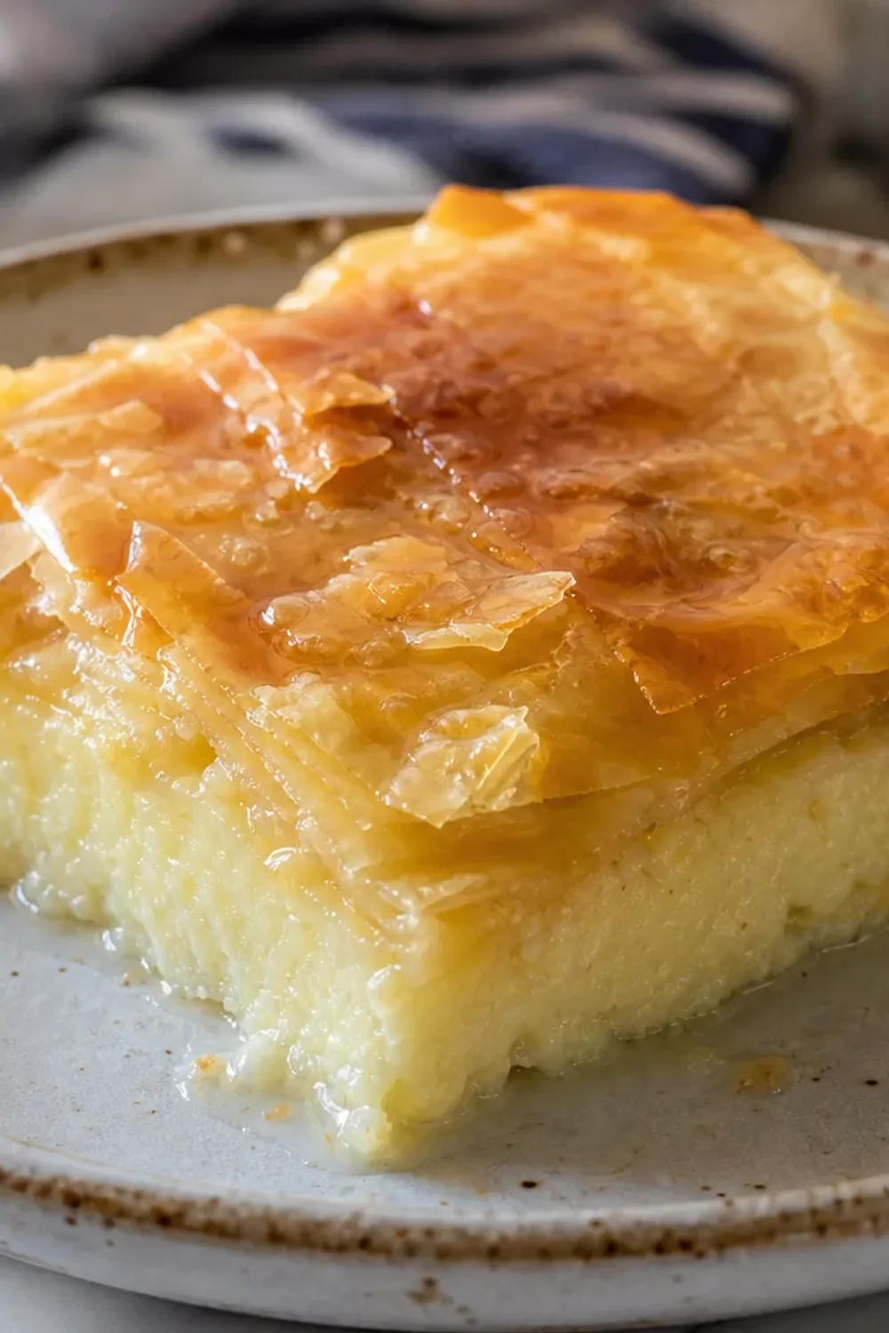 Layers of golden phyllo pastry with creamy custard, drizzled in syrup and garnished with lemon zest.