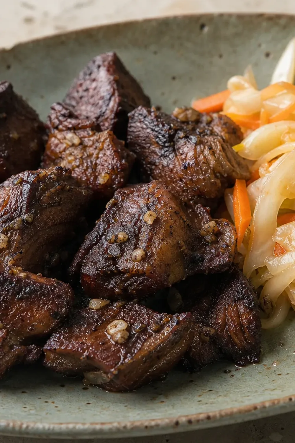 Crispy fried beef served with colorful Pikliz, showcasing vibrant textures and flavors.