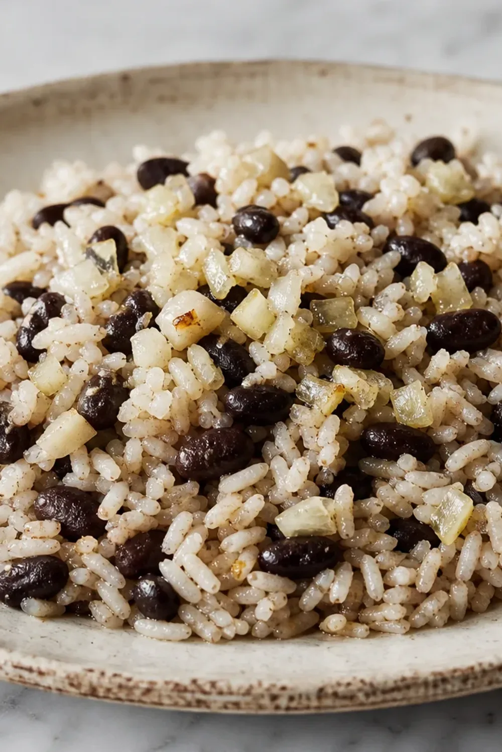 A vibrant plate of Moros y Cristianos featuring fluffy rice, black beans, and garnished with herbs.