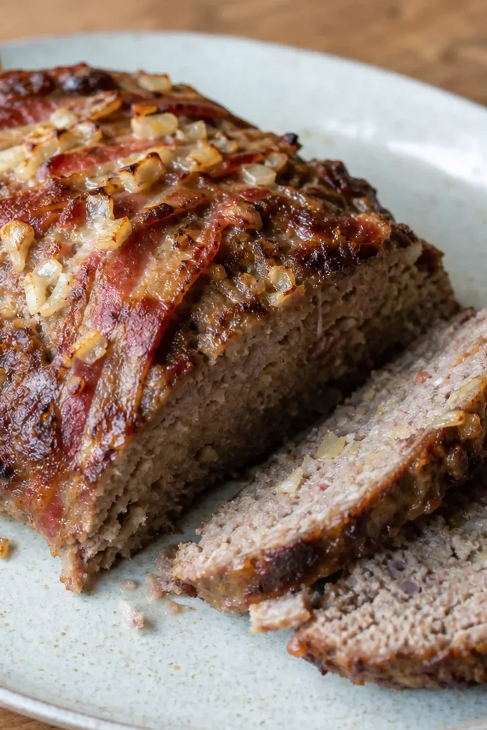 Sliced traditional Czech sekaná meatloaf garnished with herbs, showcasing a savory texture and rich color.