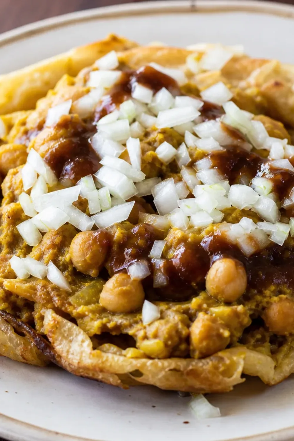 Soft golden flatbreads filled with spiced chickpeas and rich tamarind sauce, garnished with herbs.
